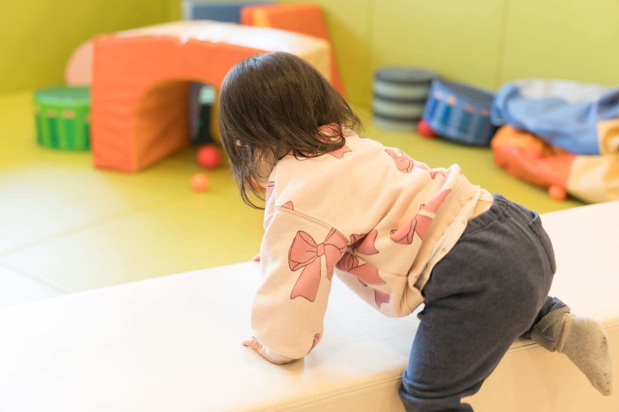 遊具で遊ぶ園児の後ろ姿